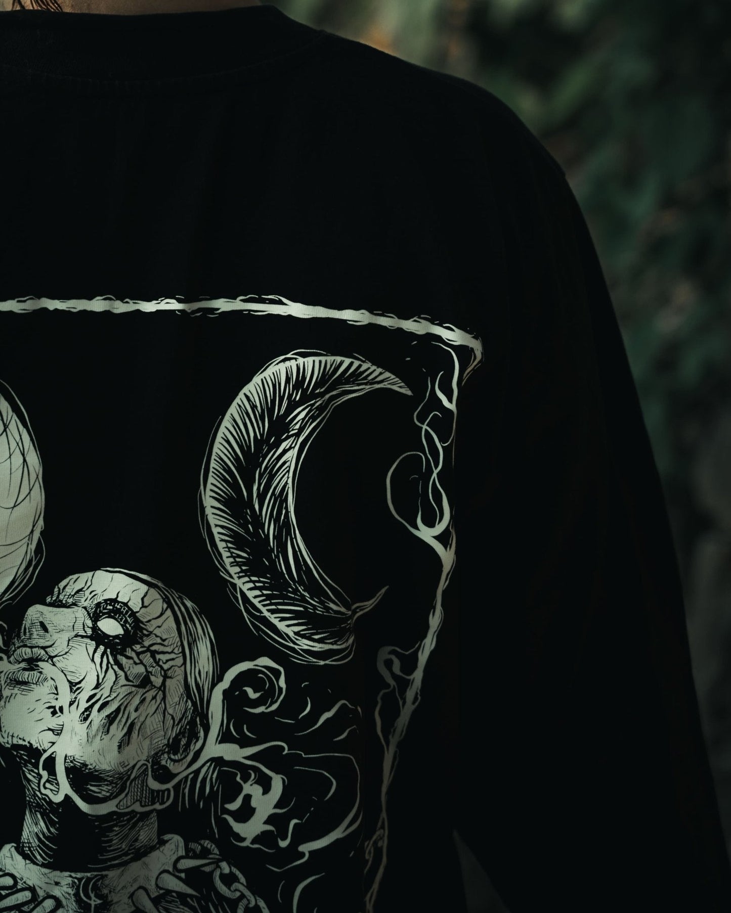 Close up of demonic woman print on Still Cursed long sleeve tee – occult gothic design in water‑based ink