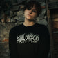 Model wearing Still Cursed long sleeve tee – heavy‑weight organic black shirt with occult hand‑drawn female artwork and oversized fit