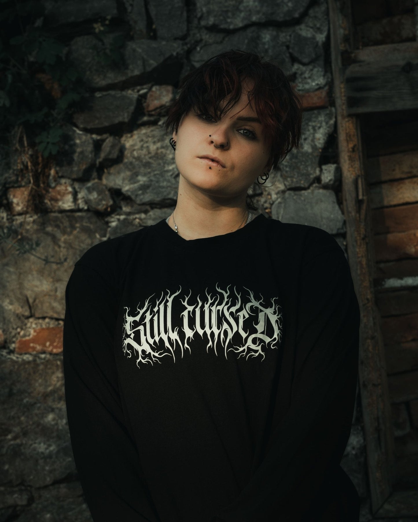 Model wearing Still Cursed long sleeve tee – heavy‑weight organic black shirt with occult hand‑drawn female artwork and oversized fit