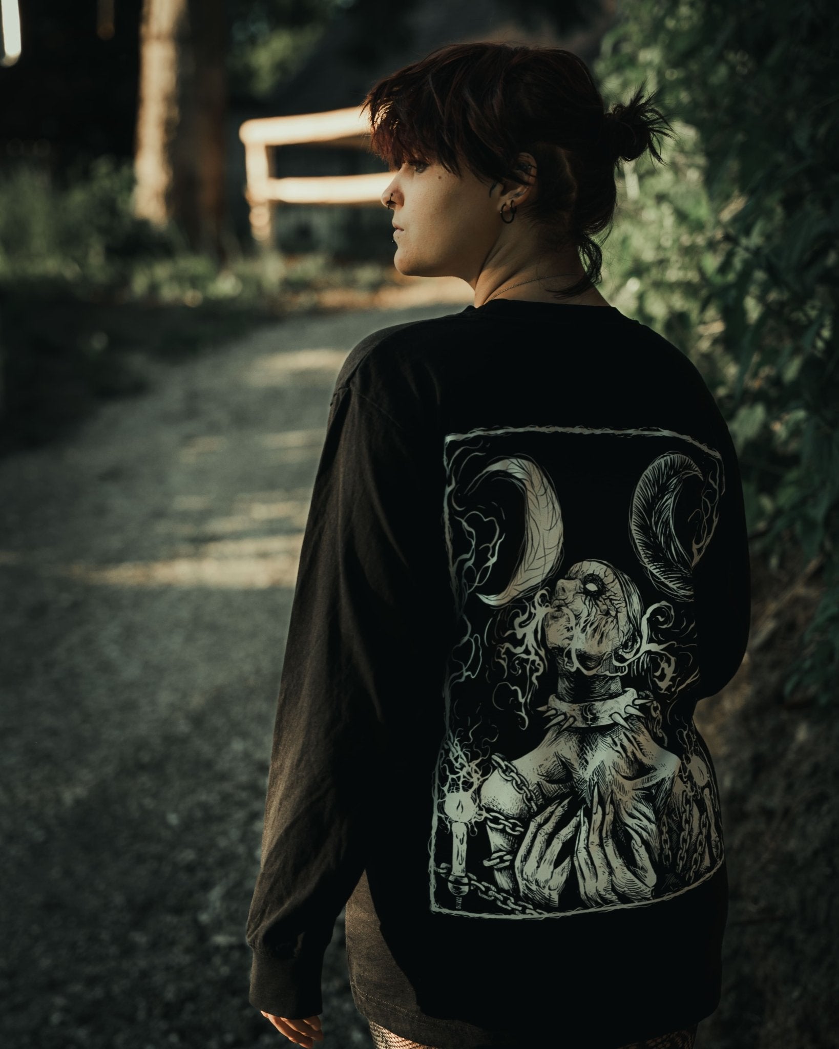 Back detail of Still Cursed long sleeve tee – inverted occult symbol and smoky blackwork illustration on organic heavy cotton